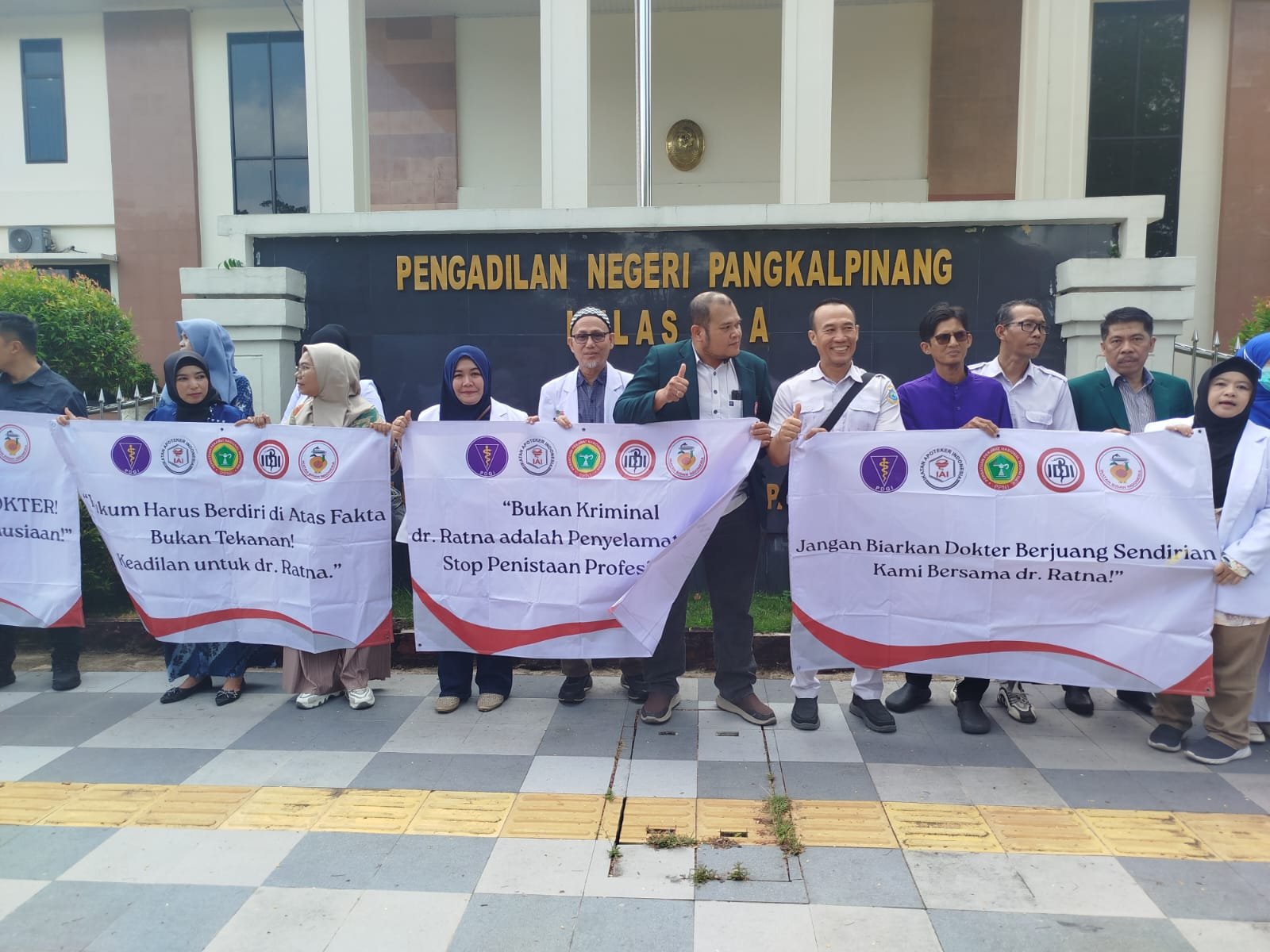 KBOBABEL.COM (PANGKALPINANG) – Suasana di depan Pengadilan Negeri (PN) Pangkalpinang, Kamis (4/6/2026), tampak berbeda dari biasanya. Sedikitnya seratus tenaga kesehatan (nakes) yang terdiri dari dokter, perawat, serta pegawai klinik dan rumah sakit berjejer rapi di sepanjang trotoar depan gedung pengadilan untuk menggelar aksi damai.